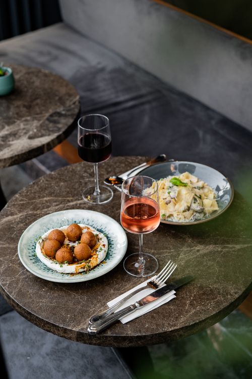 Free Chic restaurant table setup with wine and gourmet dishes, perfect for an upscale dining experience in İstanbul. Stock Photo