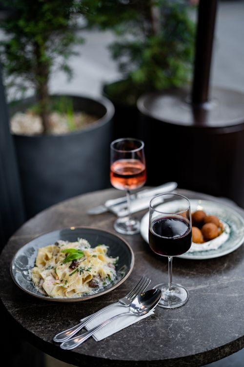 Free A sophisticated dining setup with wine and pasta on an outdoor patio in İstanbul. Stock Photo