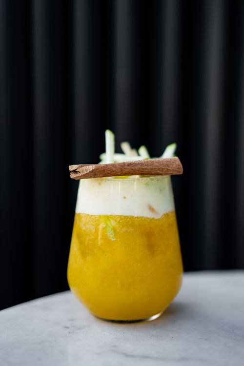 Free Vibrant citrus mocktail with creamy foam topped with cinnamon and apple garnish. Stock Photo