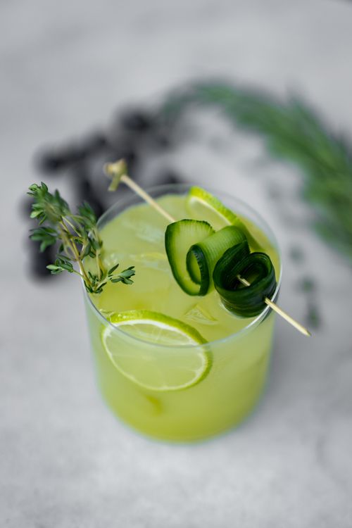 Free Bright and fresh lime and cucumber mocktail garnished with herbs, offering a crisp summer refreshment. Stock Photo