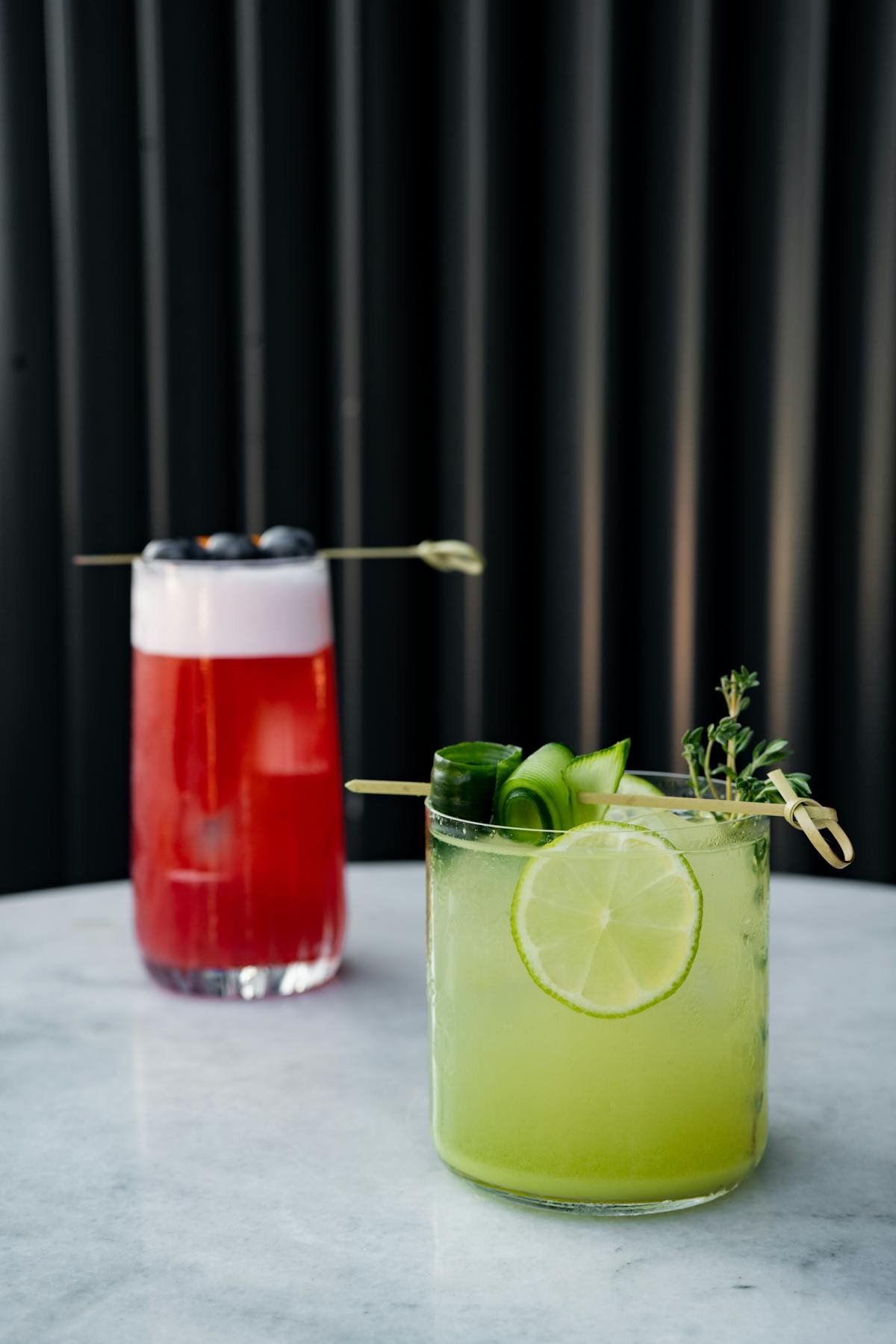 Due cocktail sul tavolo con lime, menta e cubetti di ghiaccio