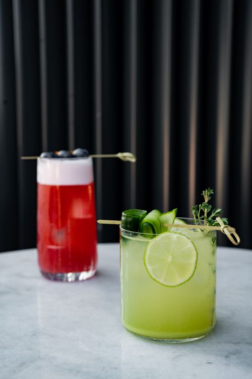 Free Two colorful cocktails displayed on a marble table, perfect for refreshment. Stock Photo