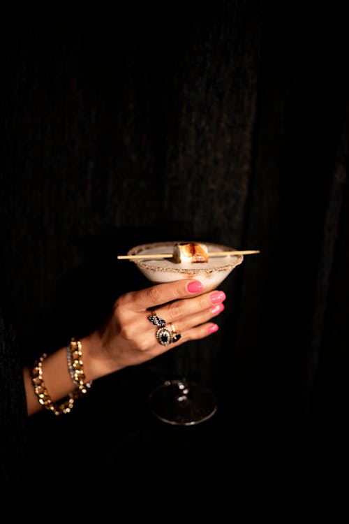 A woman holding a cocktail in her hand