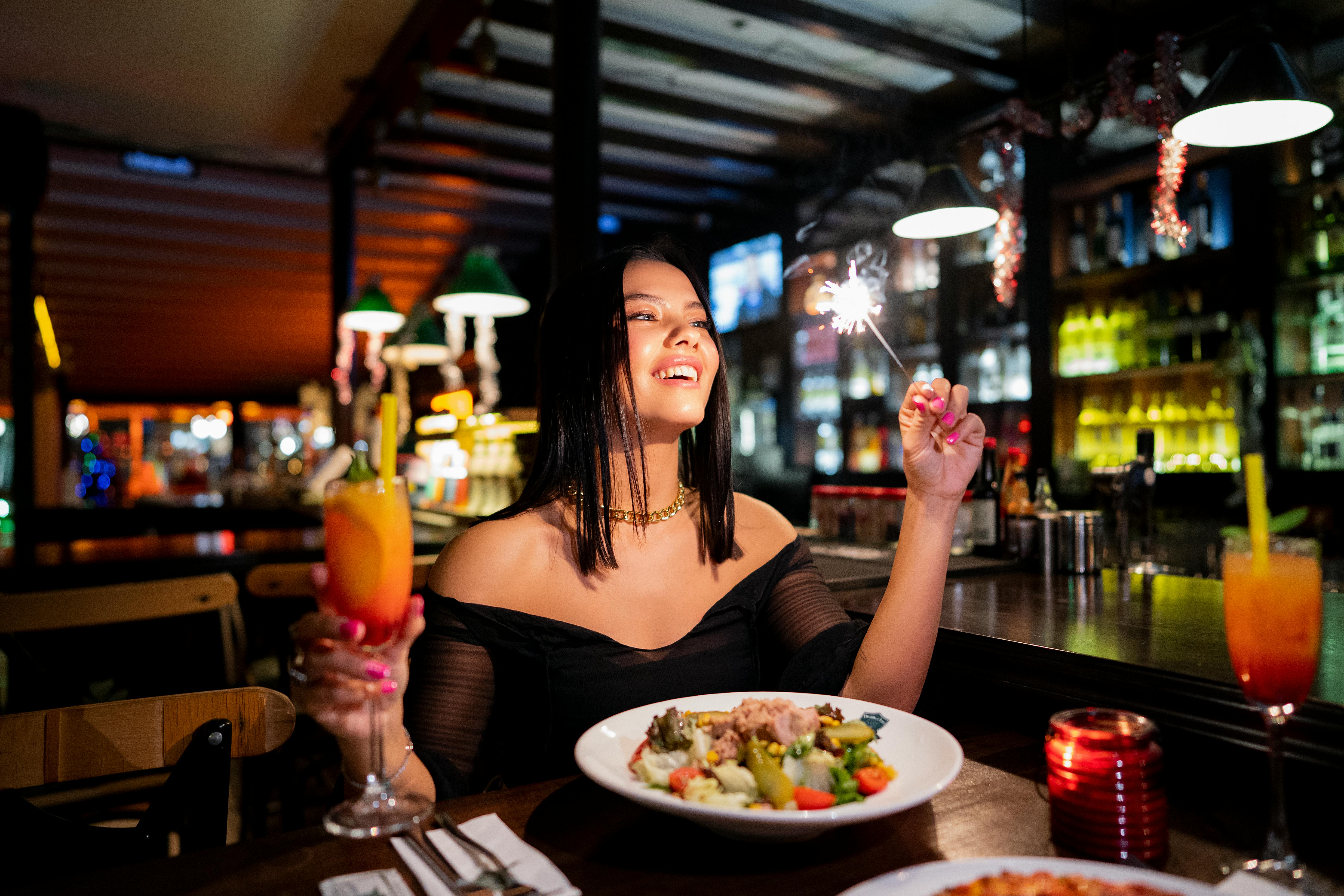 solo traveler enjoying a meal at a restaurant bar - solo trip ideas