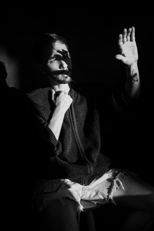 Free A striking black and white portrait of a man in dramatic lighting, creating shadows and highlights. Stock Photo
