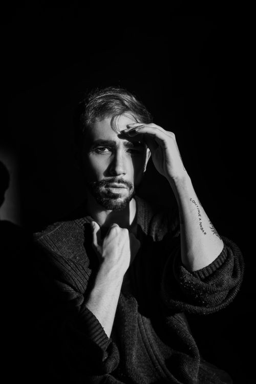 Free Artistic black and white portrait of a man with a tattoo, captured in a studio setting. Stock Photo