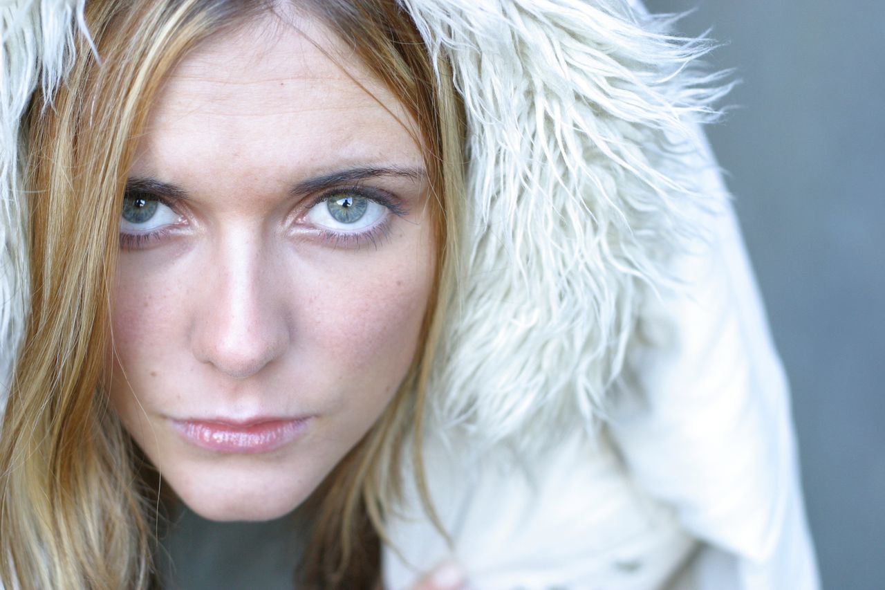 intense close up of a woman in a fur hooded jacket looking intently at
