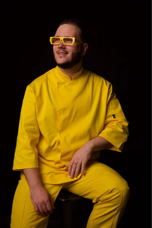 Free Man in stylish yellow outfit and glasses against black studio background. Stock Photo