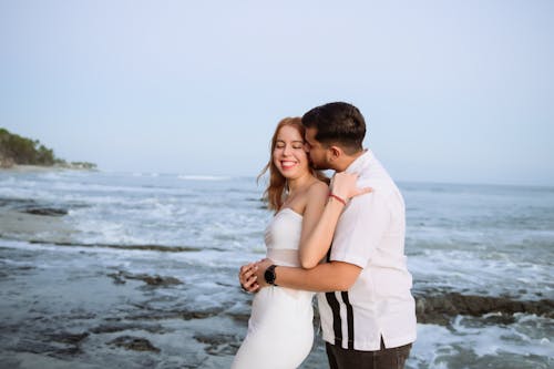 A couple embracing on the beach in front of the ocean