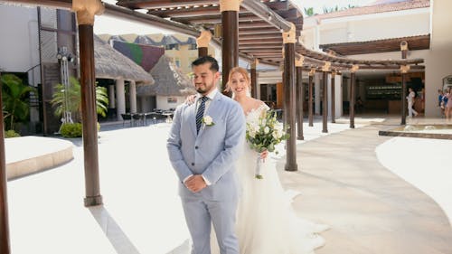 A bride and groom standing in front of a building