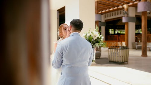 A bride and groom are standing in the lobby of a resort