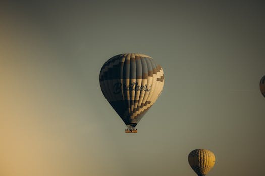 Hot air balloons gracefully flying over Cappadocia, Turkey during a serene sunrise.
