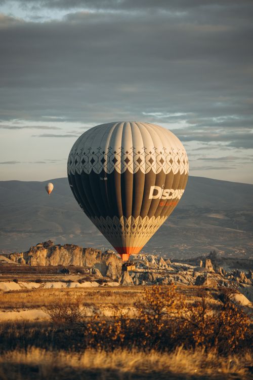 Free Stunning view of hot air balloons soaring over the unique rock formations of Cappadocia at sunrise. Stock Photo