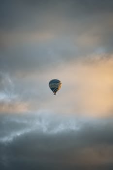 Tranquil hot air balloon floating in Cappadocia's sky at dawn, capturing serene beauty.
