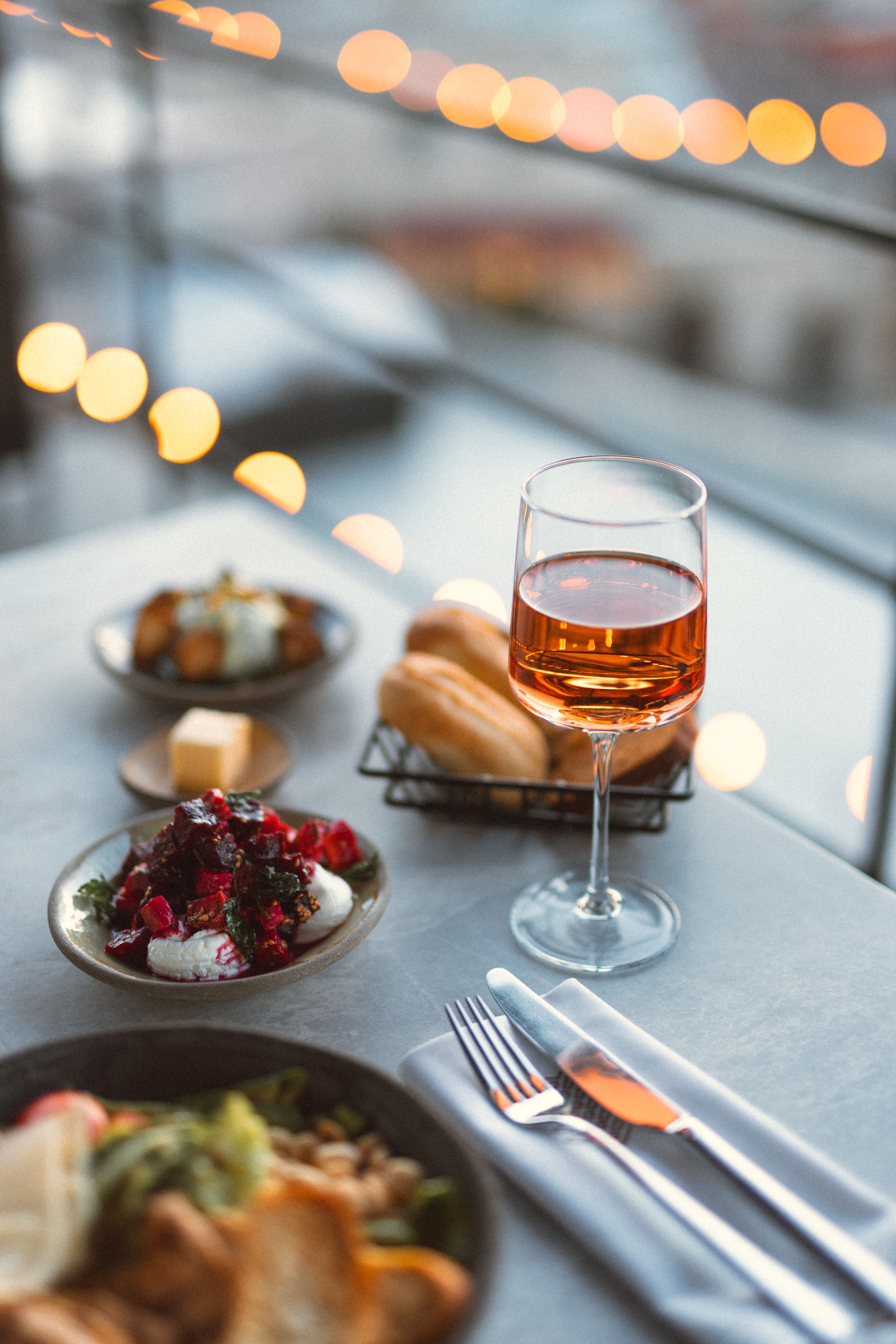 A glass of wine and a plate of food on a table · Free Stock Photo