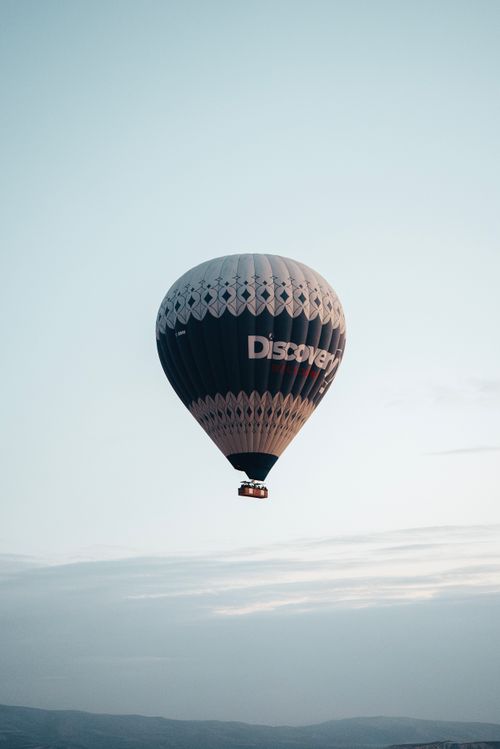 Free A stunning hot air balloon soaring over the picturesque landscapes of Ürgüp, Türkiye. Stock Photo