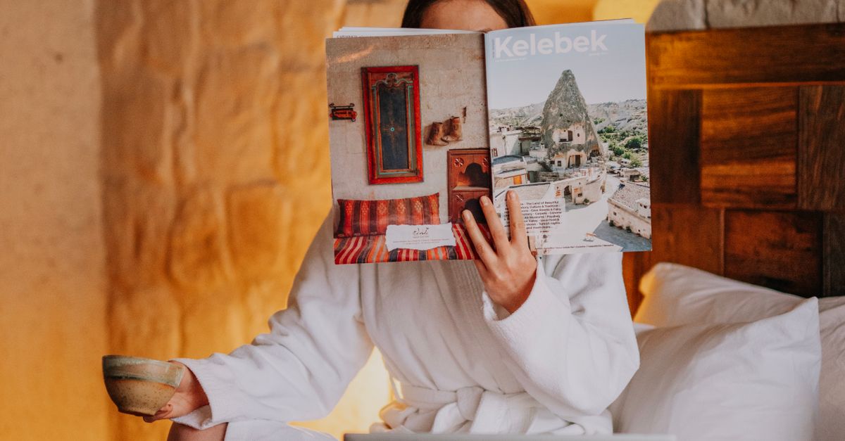 The Reading Robe A woman in a robe reading a book on a bed · Free Stock Photo