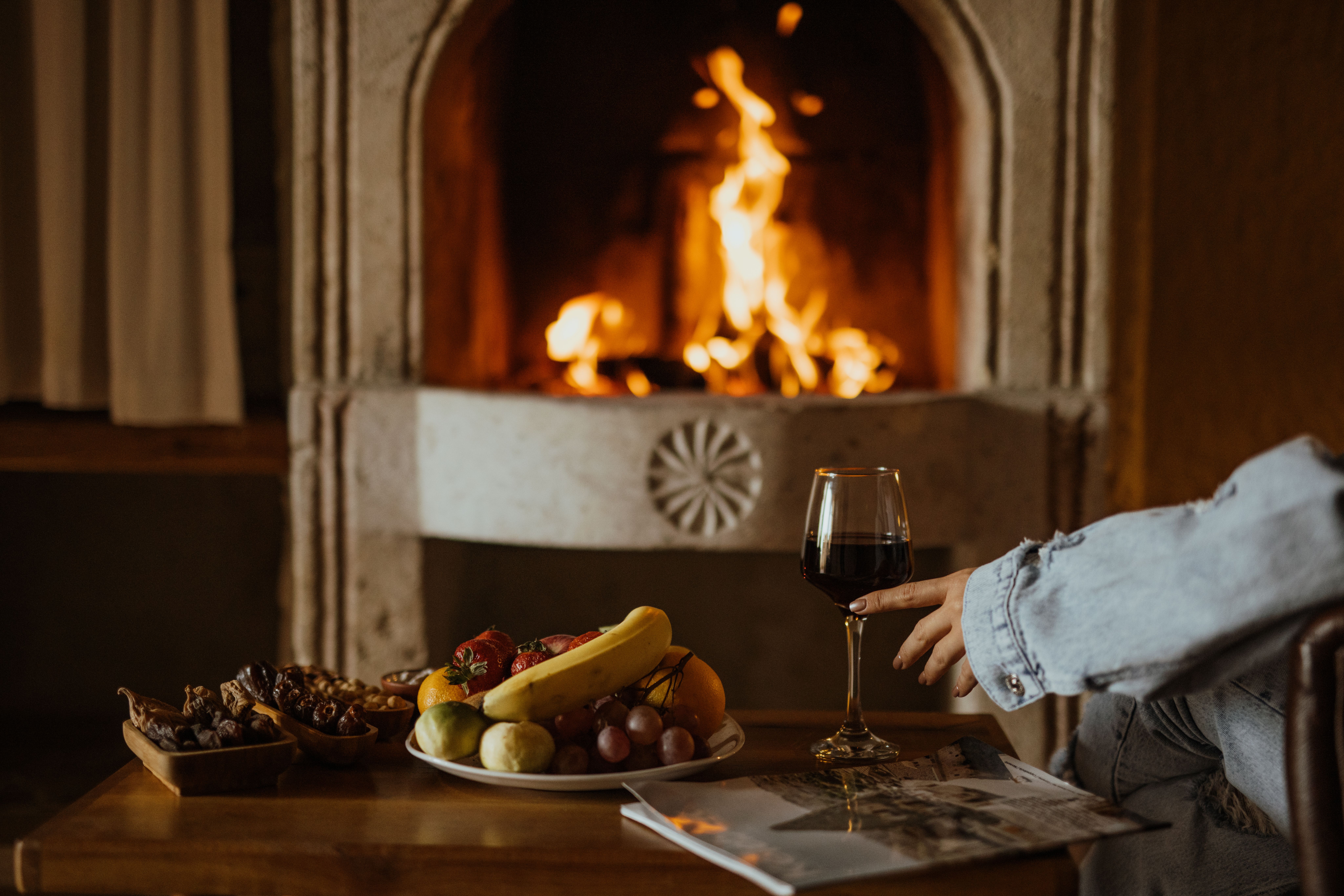 Warm scene with fruits and wine by a roaring fireplace, ideal for cozy dining. Warm scene with fruits and wine by a roaring fireplace, ideal for cozy dining.