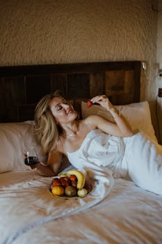 Woman enjoys fruit and wine in a cozy hotel room, Ürgüp, Türkiye.