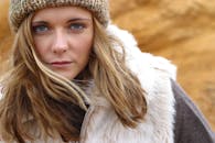 一位穿着无帽线和毛皮大衣的女性在户外的特写肖像，散发出冬天的氛围