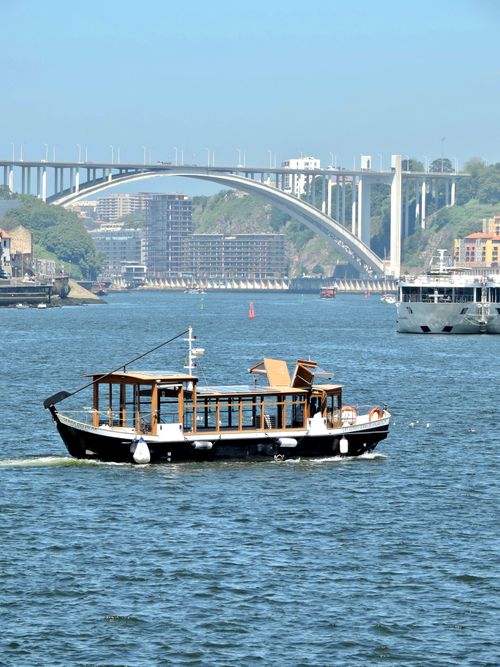 Free Boat cruising on Douro River with Arrábida Bridge in Porto on a sunny day. Stock Photo