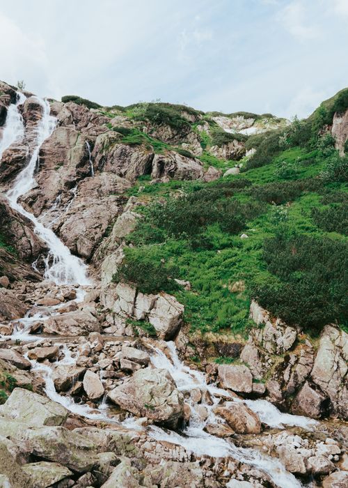 Free A beautiful mountain waterfall cascading over rocks in the Tatra mountains during summer. Stock Photo