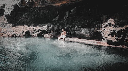 Person Sitting Beside a Body of Water