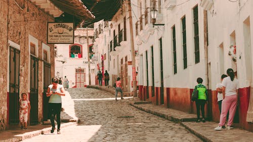 People walking down a narrow street in a city
