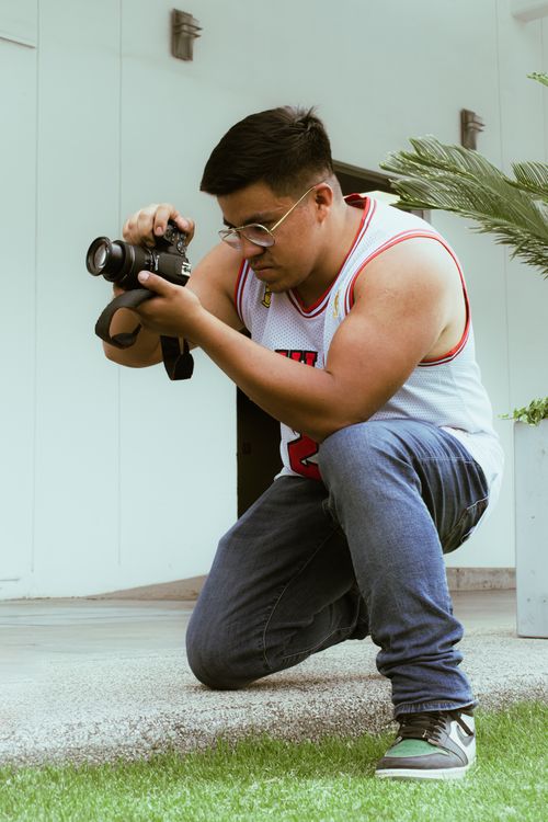 Free Man in sportswear taking photos with a camera outdoors in Puebla, Mexico. Stock Photo