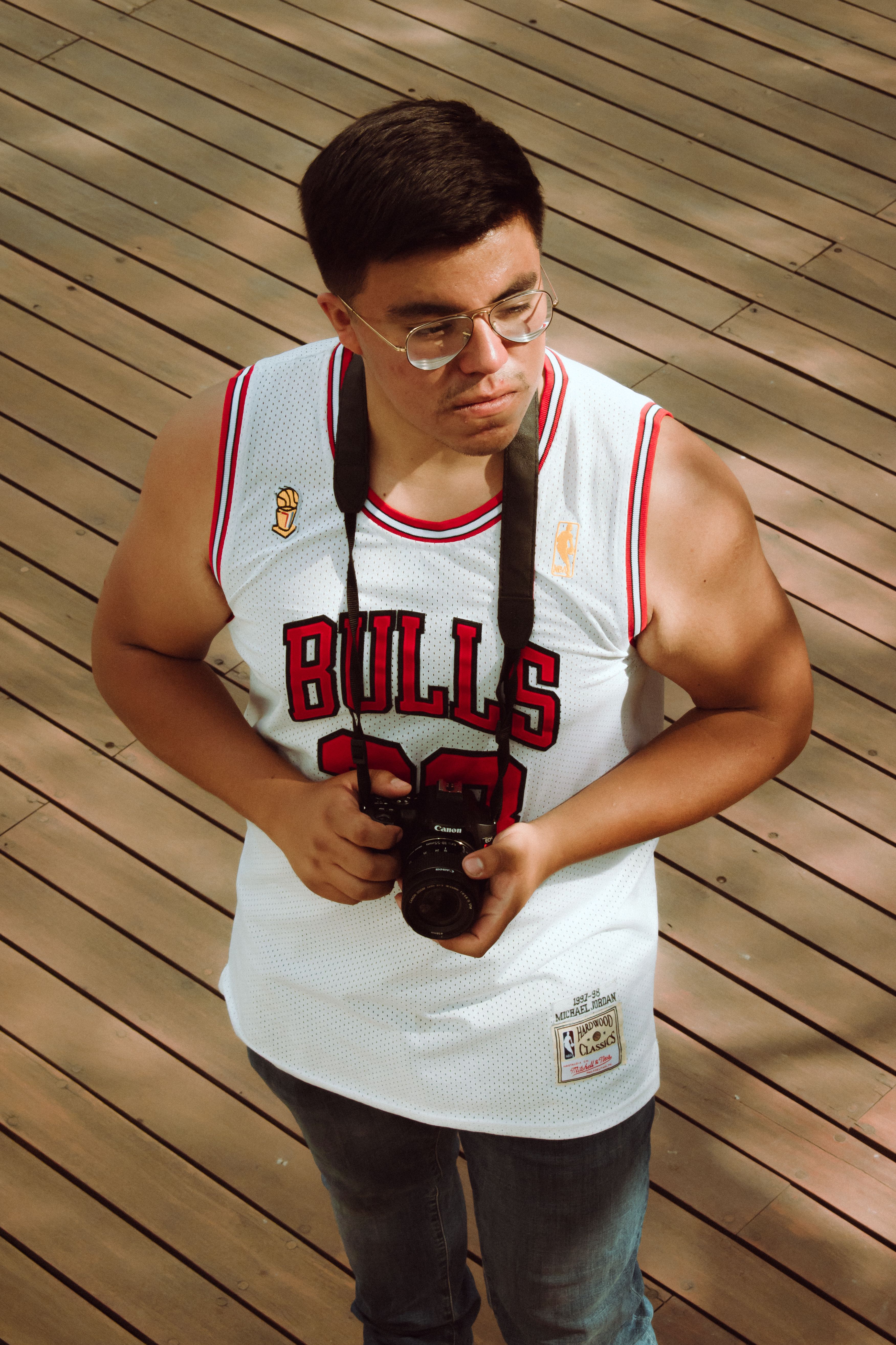Man in Chicago Bulls jersey holding a camera outdoors in Puebla de Zaragoza.