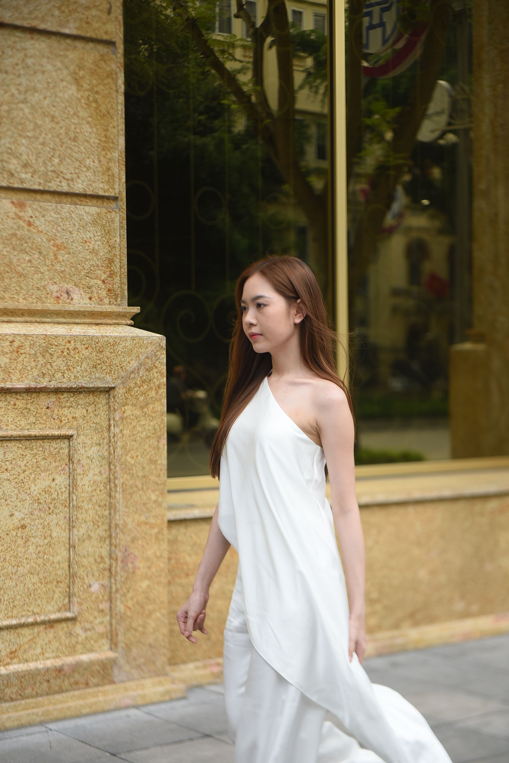 A Woman in a White Dress Walking on the Sidewalk · Free Stock Photo
