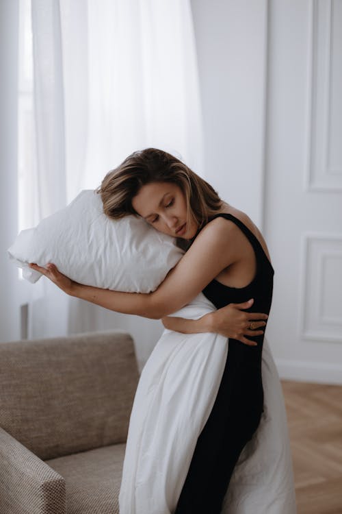 A woman hugging a pillow in a living room