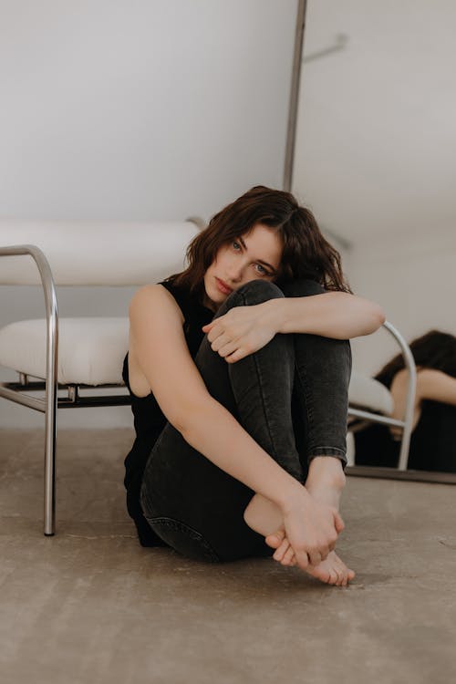 A woman sitting on the floor with her legs crossed