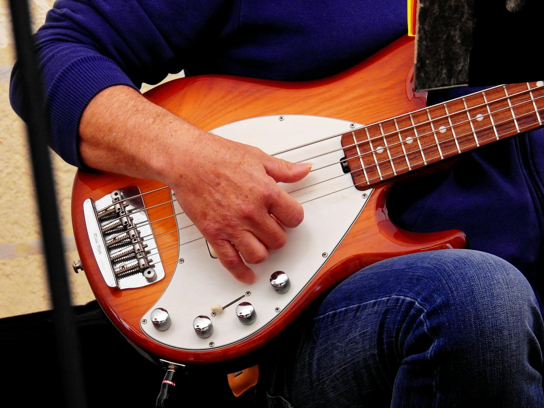 Detailed shot of a musician's hand on a bass guitar during a live performance.. detailed, shot, musicians