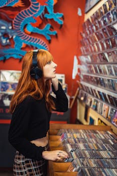 Young woman with headphones selecting music CDs in a colorful record store.