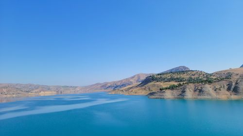 Free Stunning aerial photo of Dokan Lake with clear skies and scenic hills in Iraq. Stock Photo