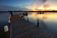 木码头、船只与水面倒影中的宁静日落