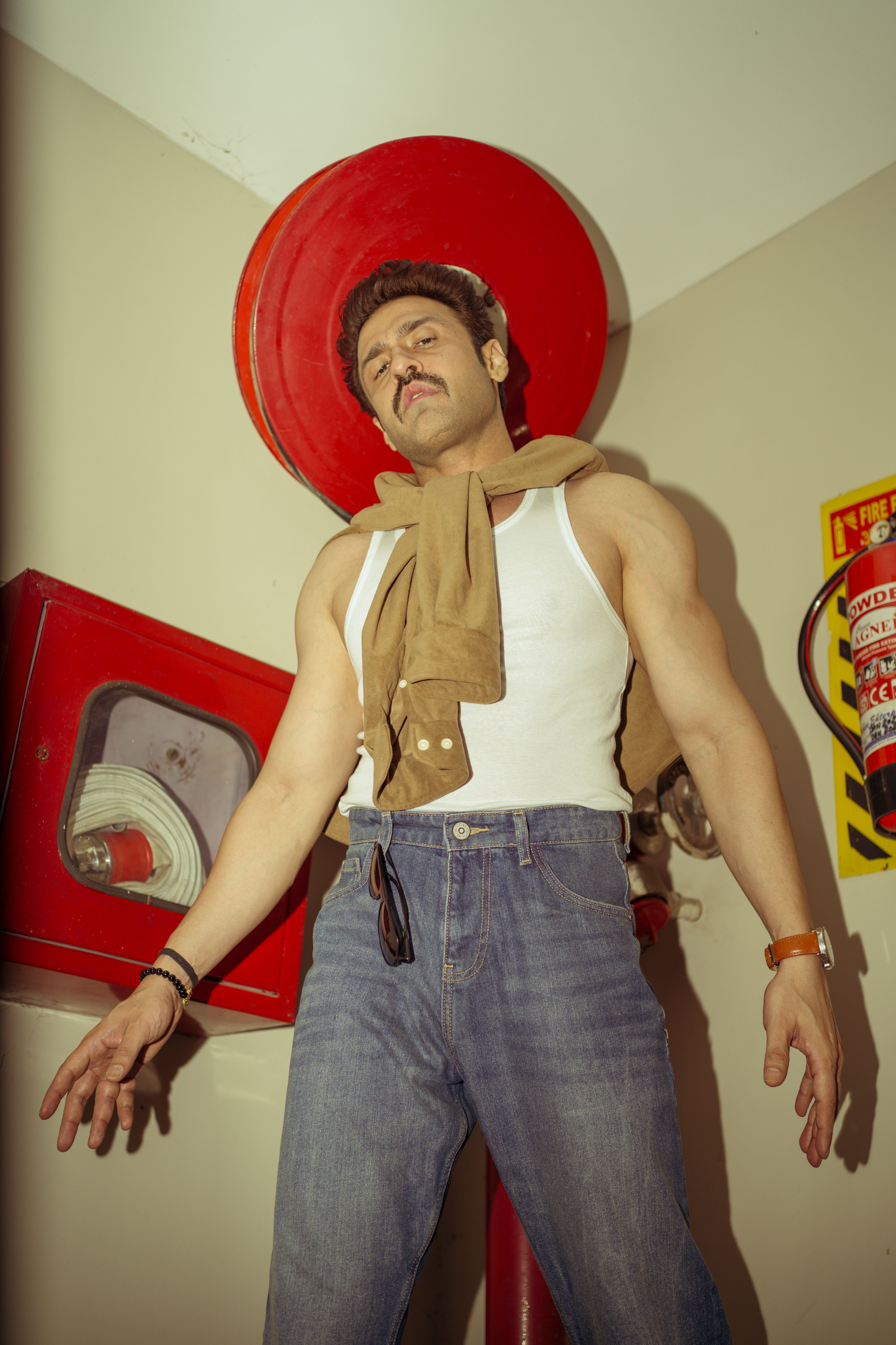 Portrait of a man posing against an indoor backdrop in casual fashion attire. Trendy and confident.