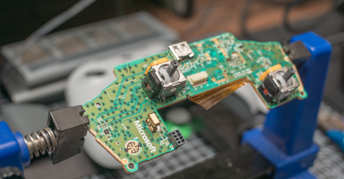 Detailed view of a gaming controller circuit board in repair setup.