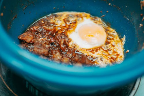 A slow cooker with a fried egg inside
