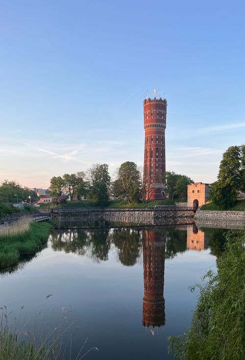 Free Scenic view of the Kalmar water tower reflecting in a tranquil lake at dusk in Sweden. Stock Photo