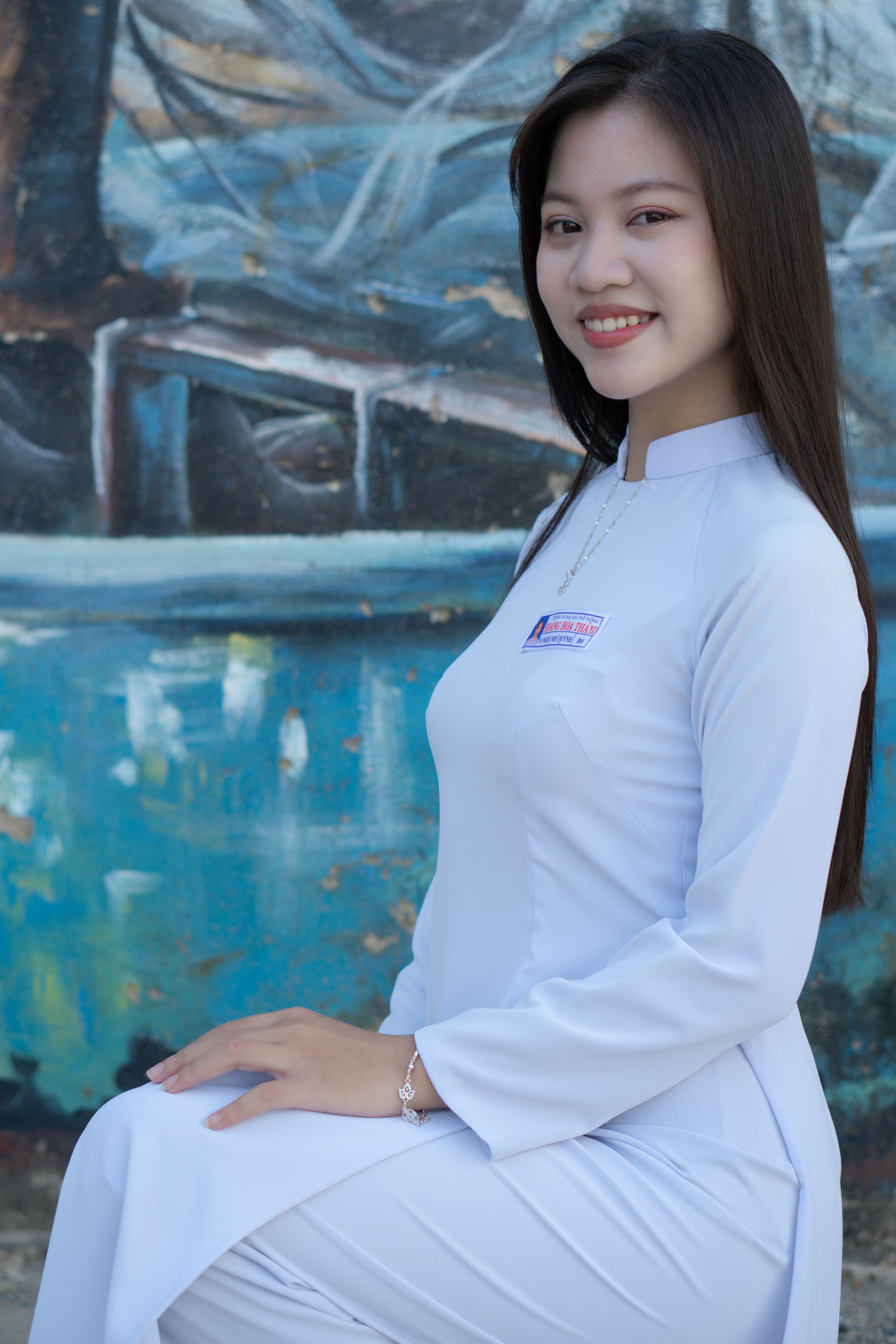 Elegant portrait of a woman in traditional Ao Dai attire with a colorful background.