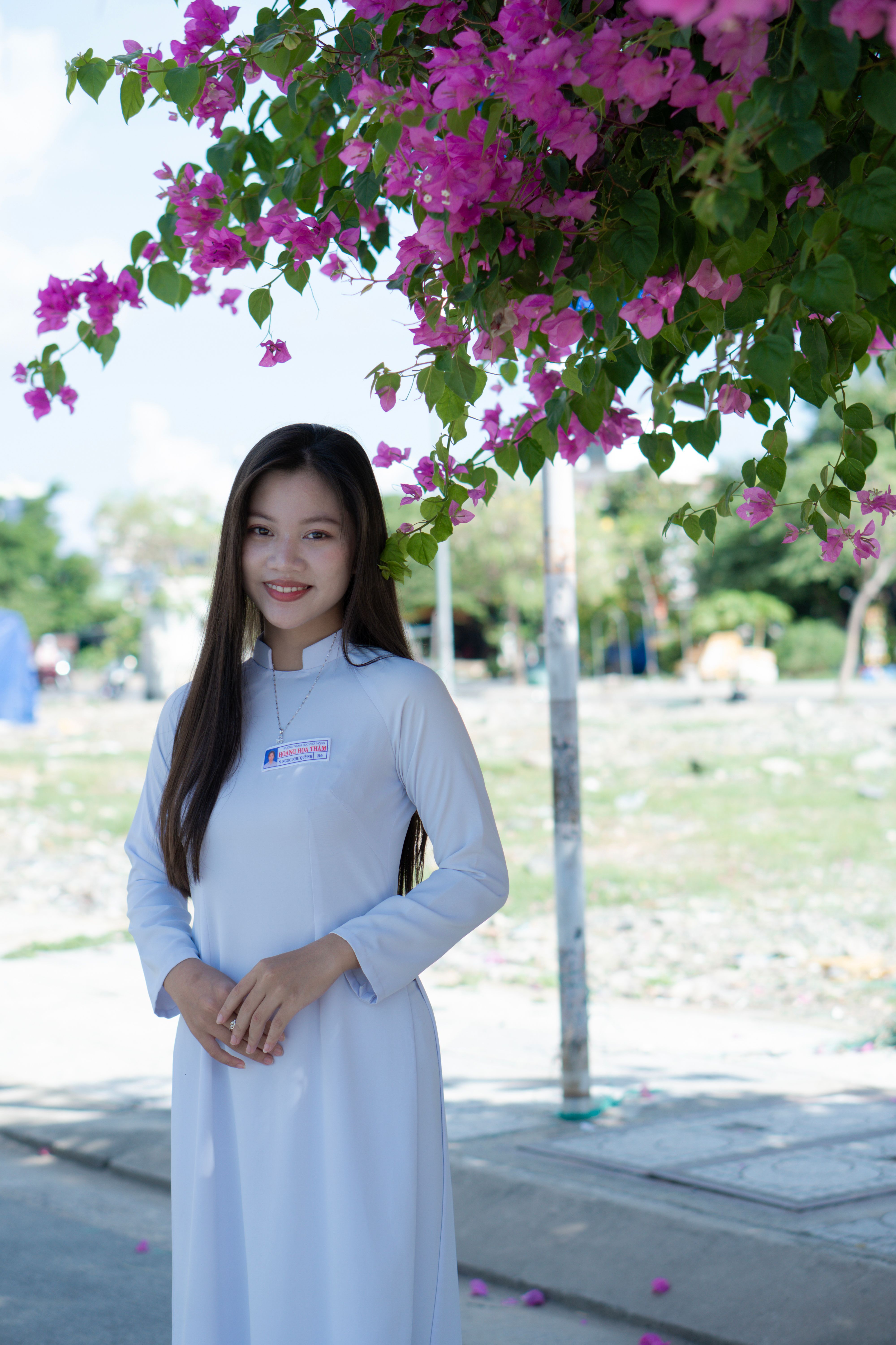 Smiling Woman in Traditional Dress under Tree · Free Stock Photo
