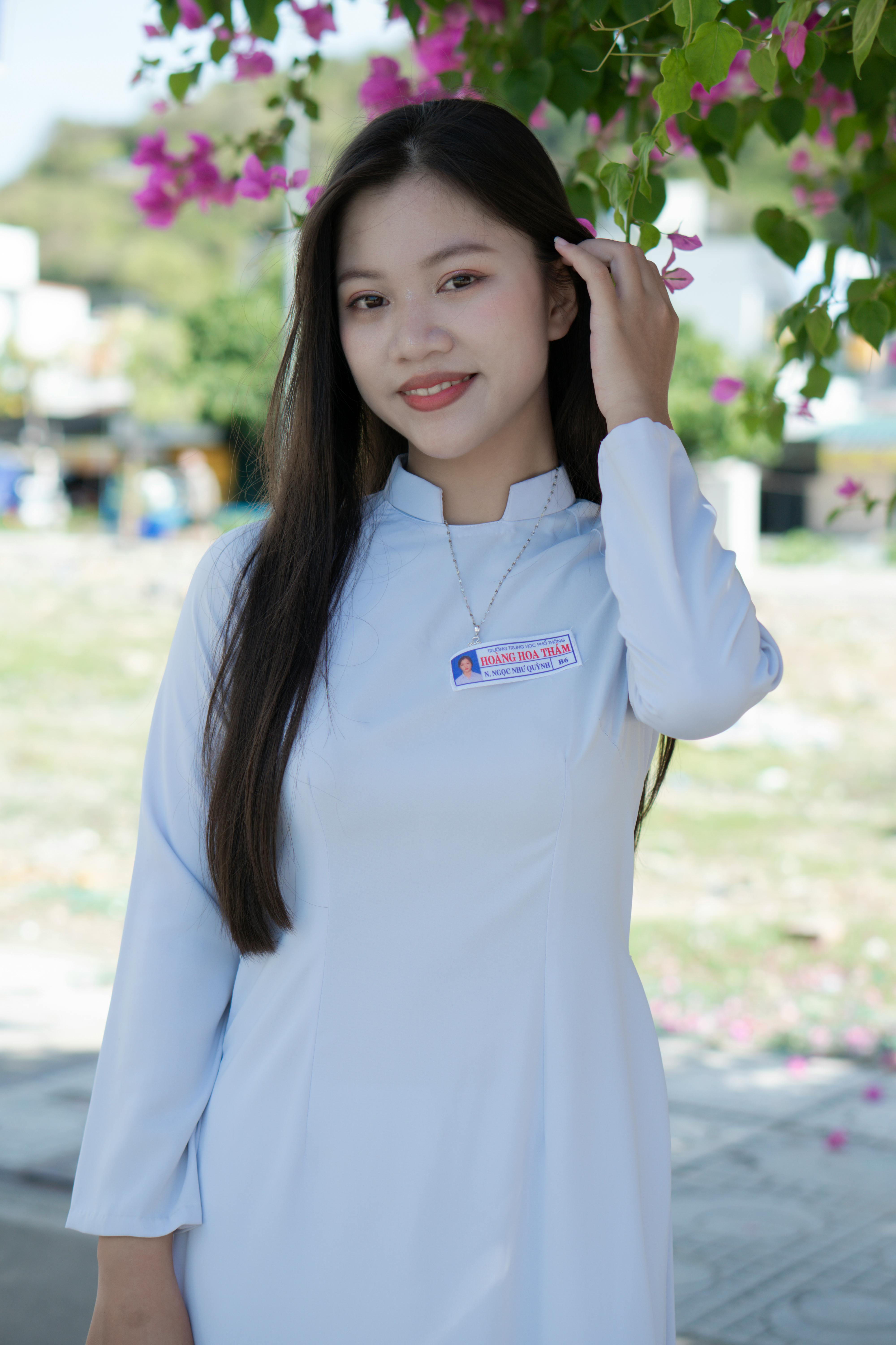 Asian woman in traditional clothing outdoors, exuding elegance and grace.