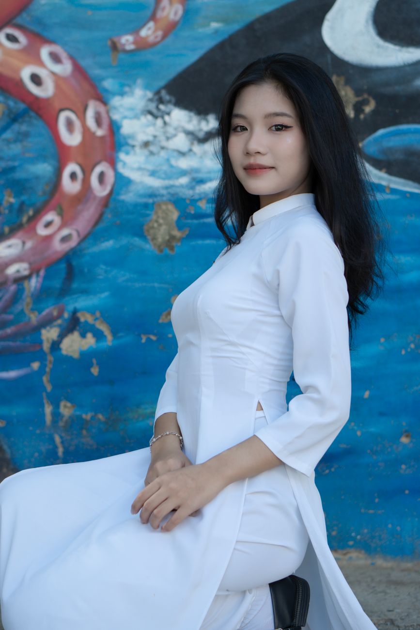 Portrait of an Asian woman in a white Ao Dai, blending tradition with elegance.