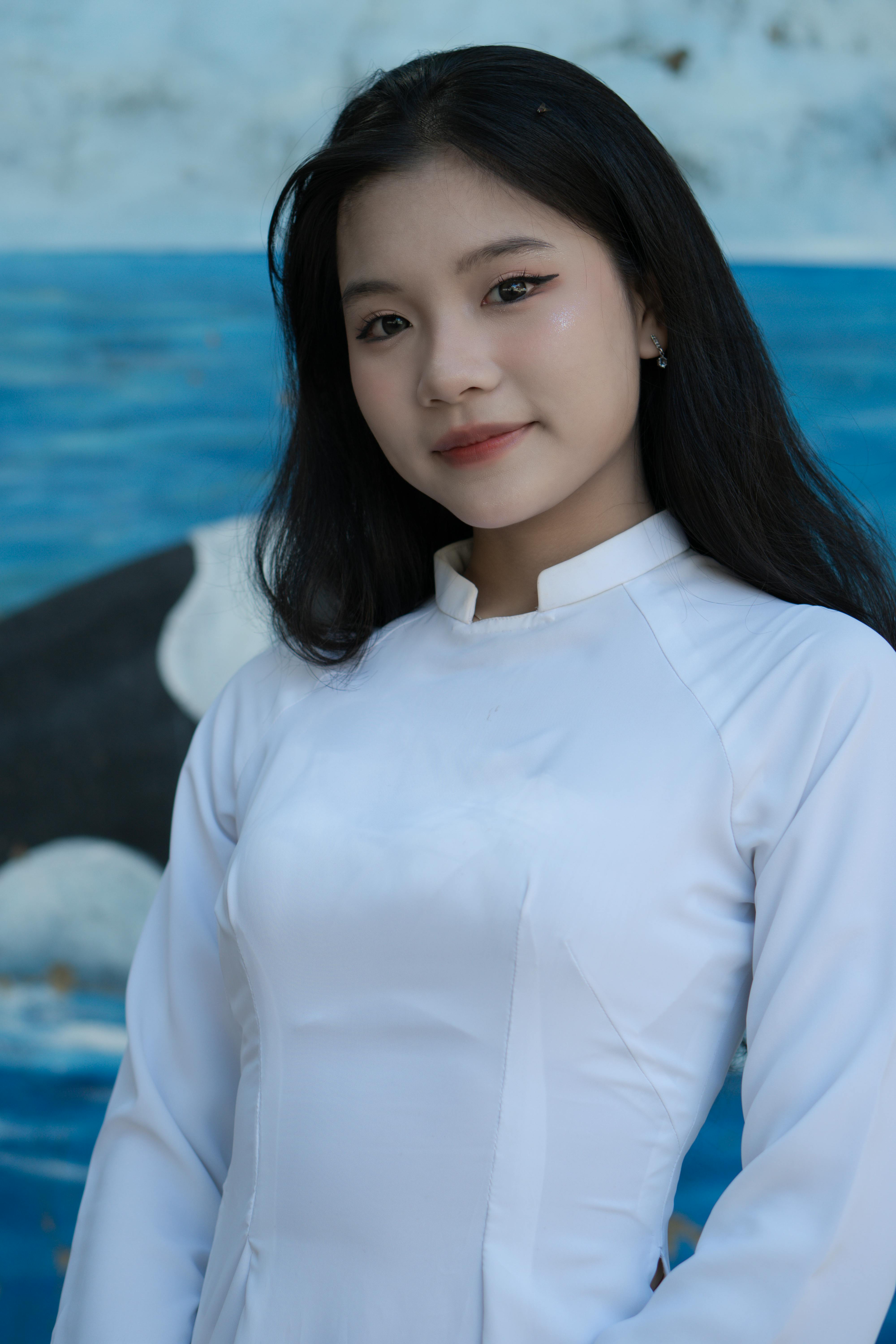 Portrait of an Asian woman in traditional attire with a serene background.