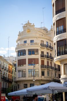 A detailed view of a historic building facade in downtown Valencia, Spain, under a clear blue sky.