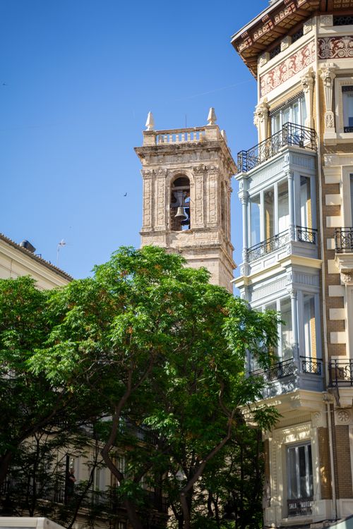 Free Capture of a historic bell tower amidst urban architecture and greenery in Valencia, Spain. Stock Photo
