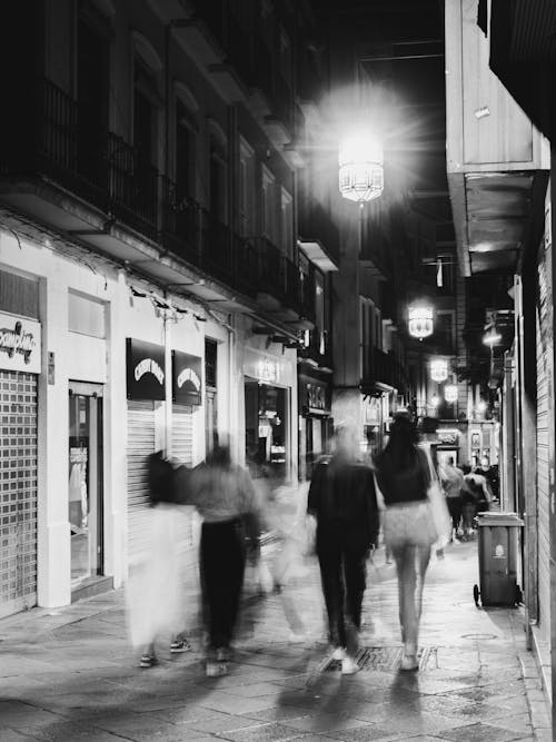 Black and white photo of people walking down a street