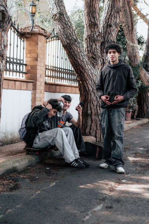 Free Three young adults socializing in an urban park setting, enjoying leisure time together. Stock Photo